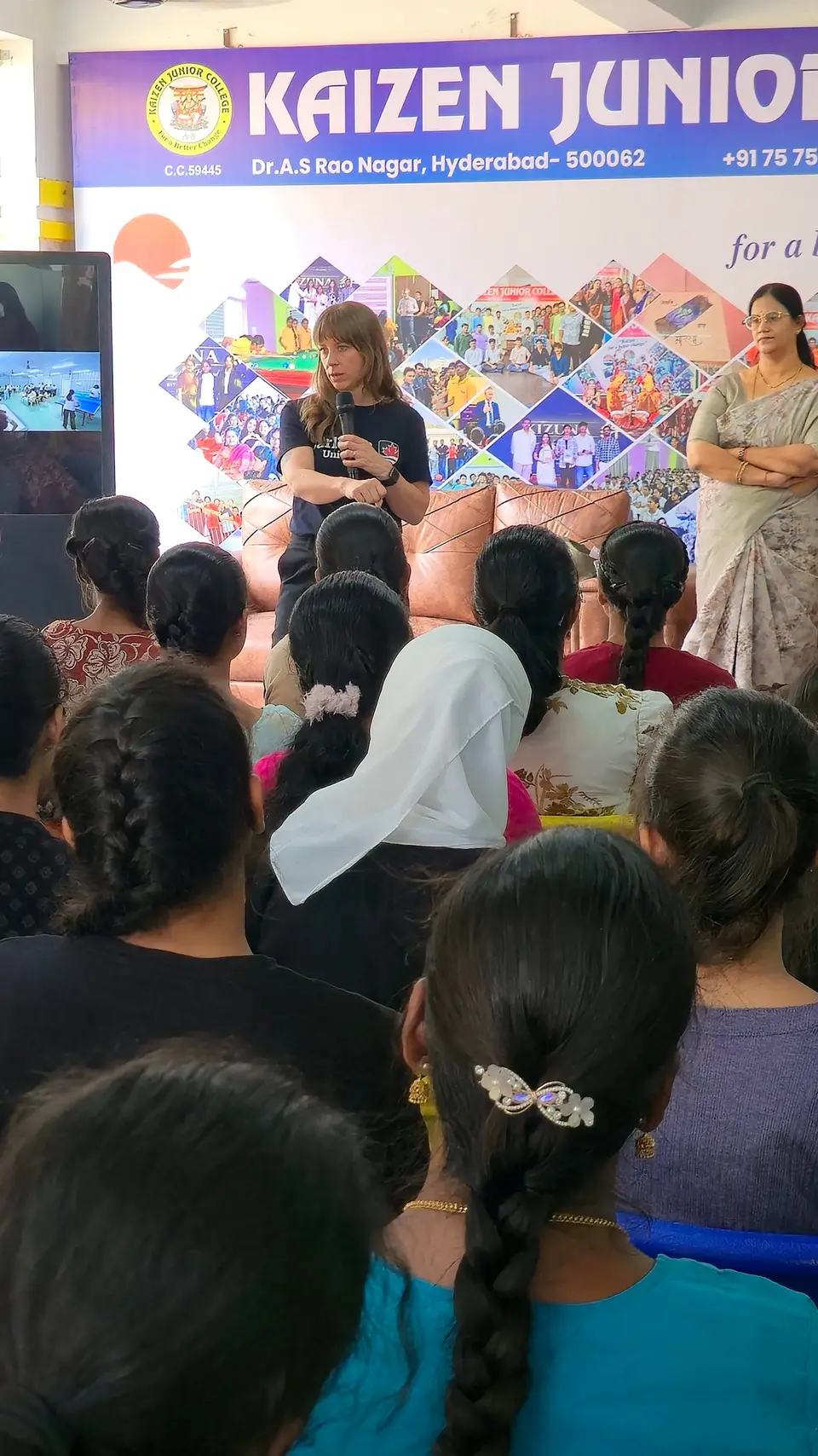 Parents and students at a college event in front of the Kaizen banner