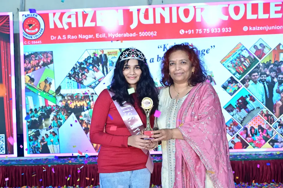 A student receiving a trophy from a guest at a college celebration